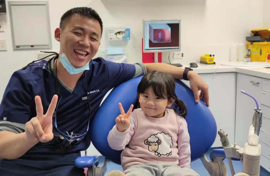 Child and Dentist have peace sign